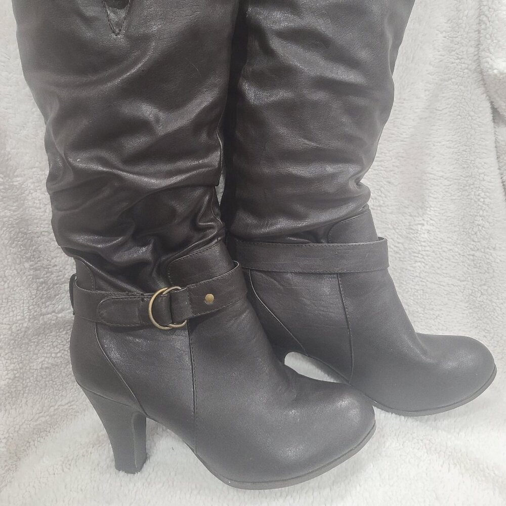 Heeled dress boots go to knee.